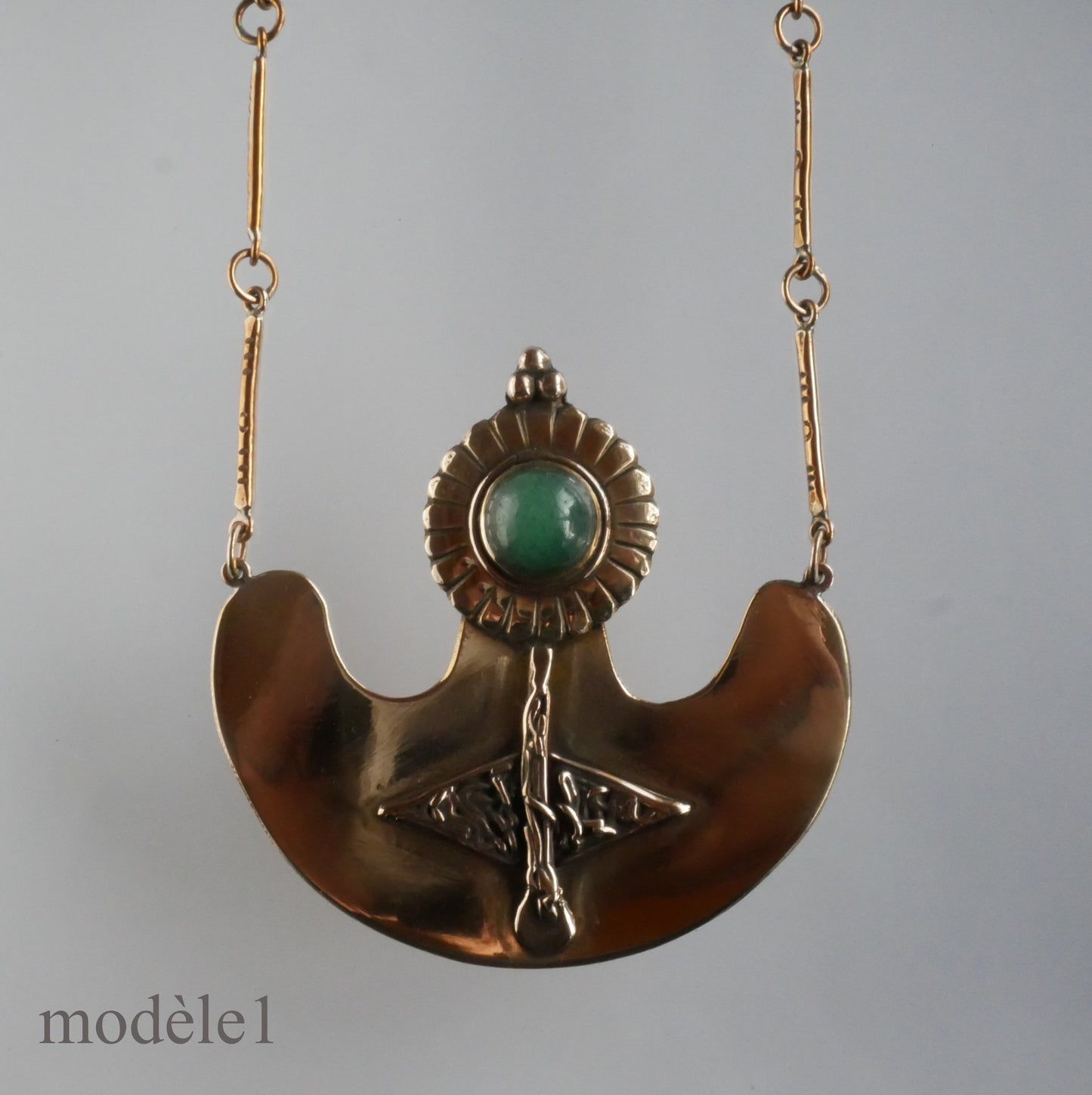 Pendentif en bronze orné d'un cabochon et de motifs sculptés