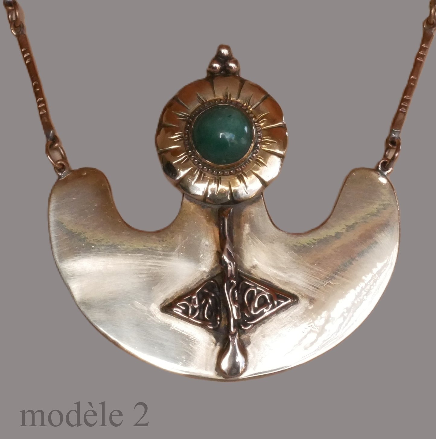 Pendentif en bronze orné d'un cabochon et de motifs sculptés