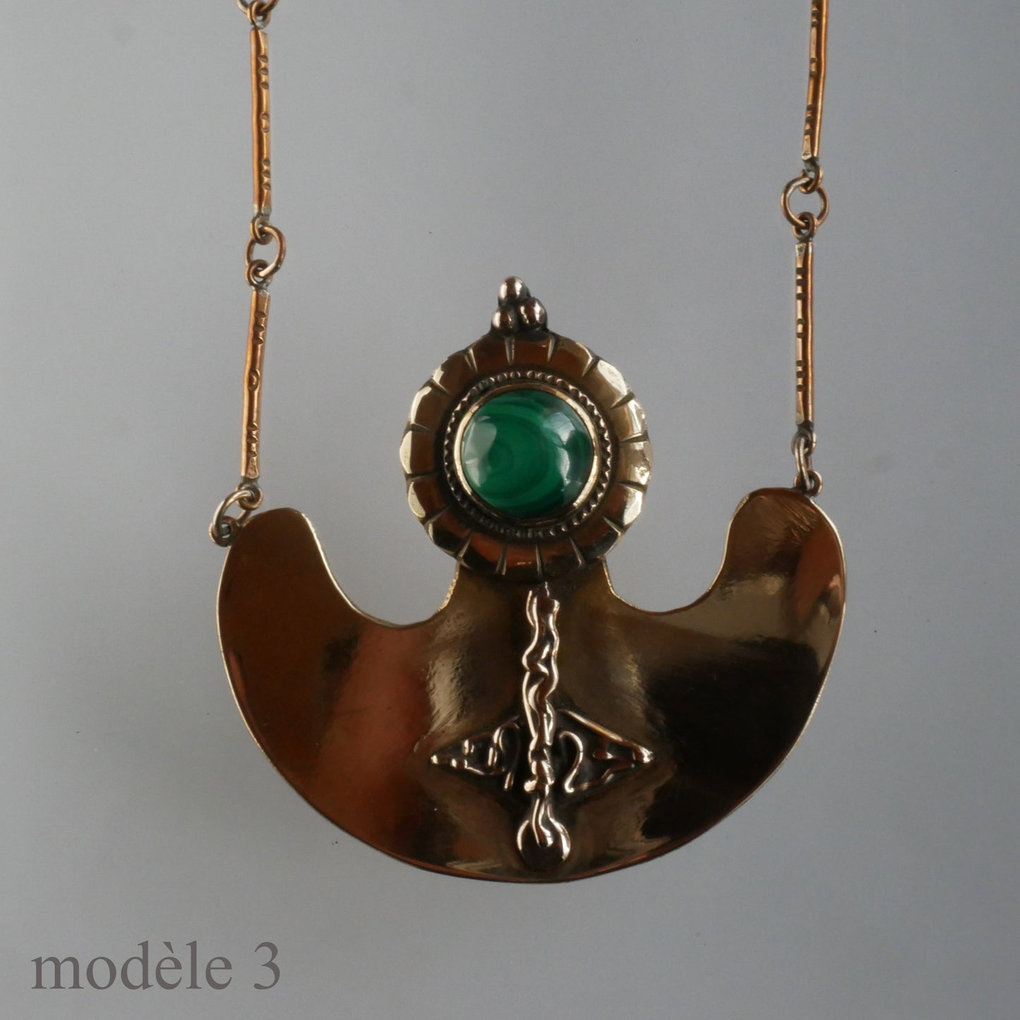 Pendentif en bronze orné d'un cabochon et de motifs sculptés