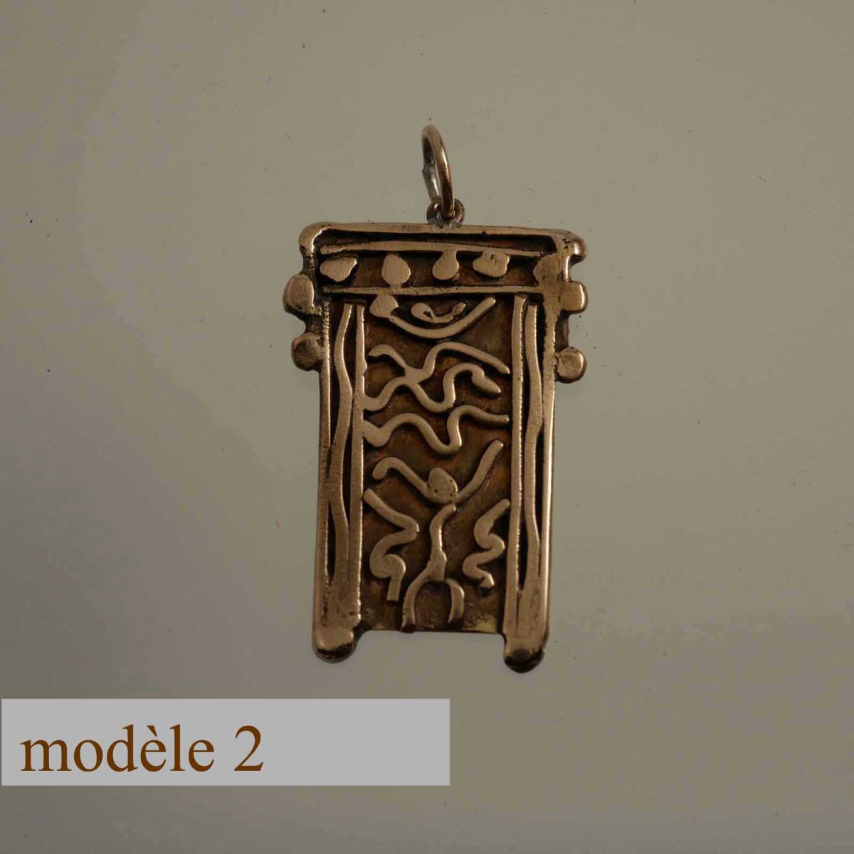 pendentif en bronze décoré de motifs sculptés