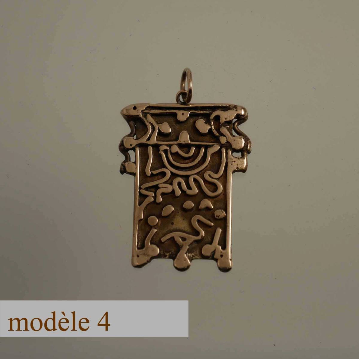 pendentif en bronze décoré de motifs sculptés