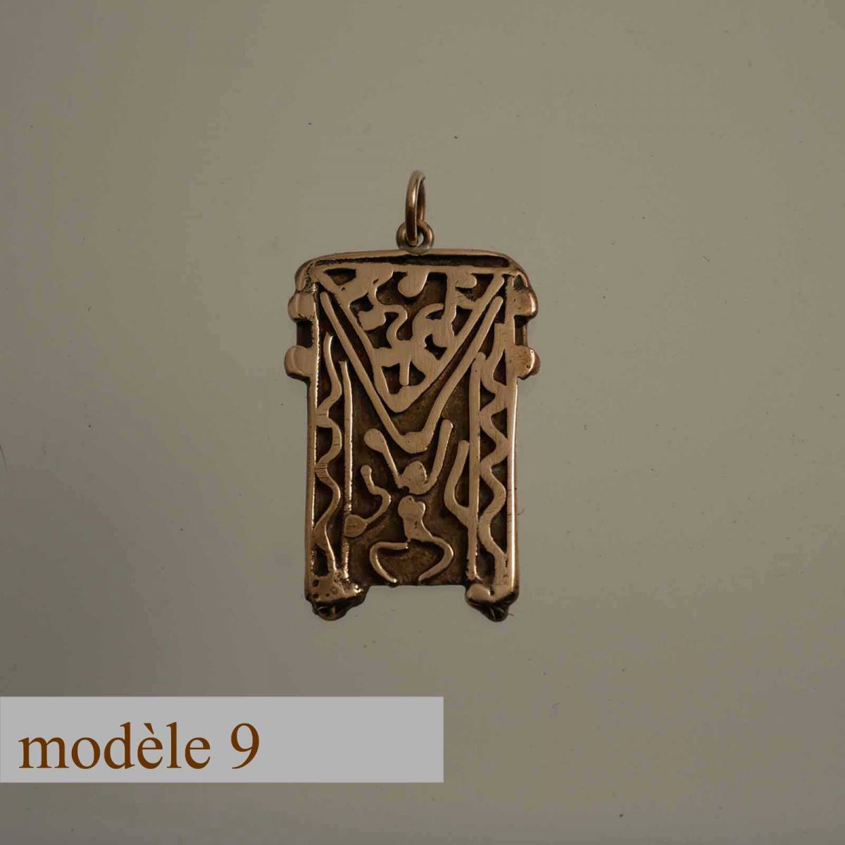 pendentif en bronze décoré de motifs sculptés