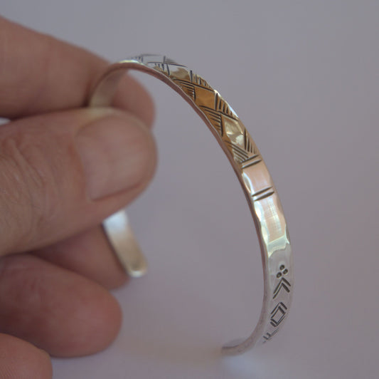 hammered silver bracelet with engraved motifs 