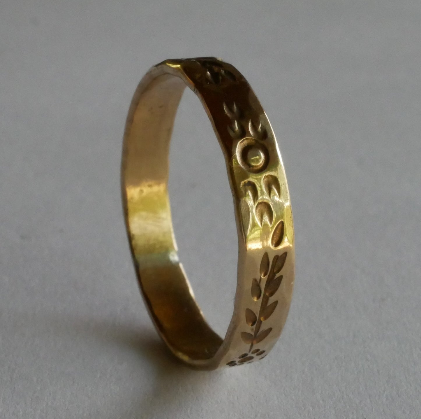 bague en bronze gravée de motifs végétaux et solaires