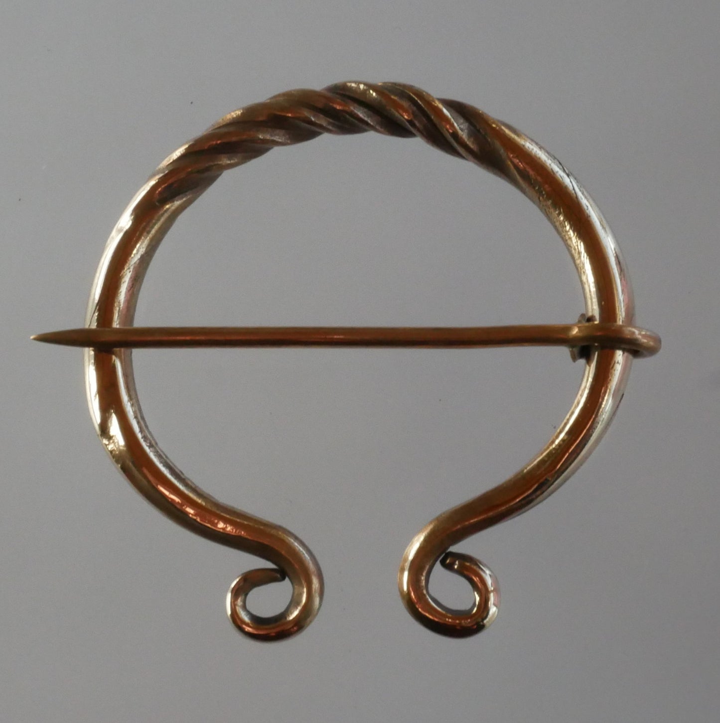 carved bronze fibula
