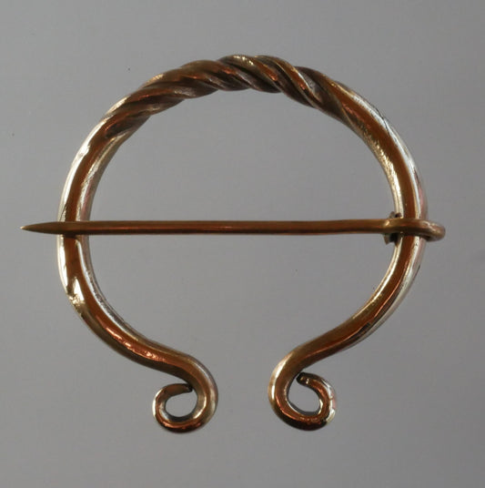 carved bronze fibula