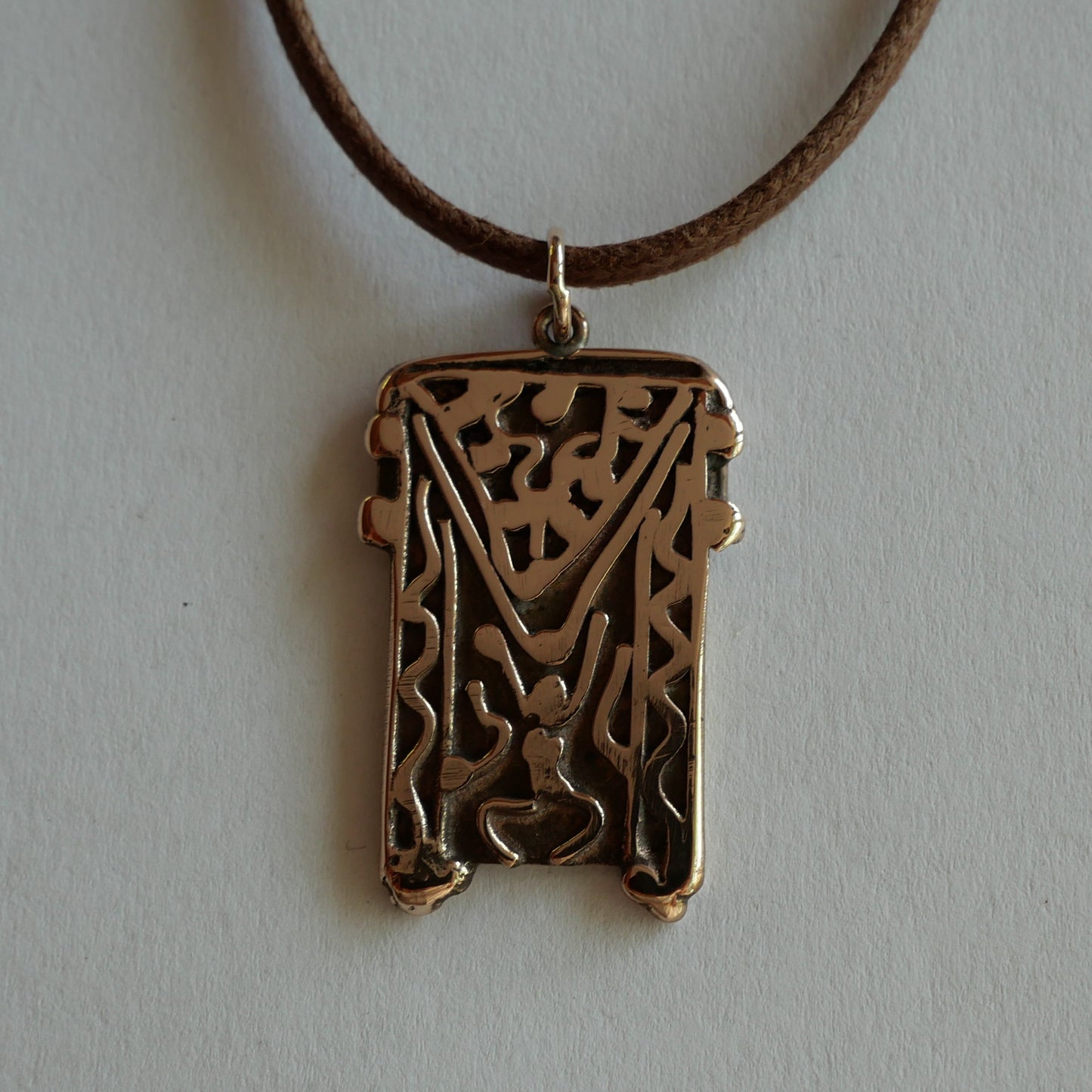 bronze pendant decorated with carved motifs