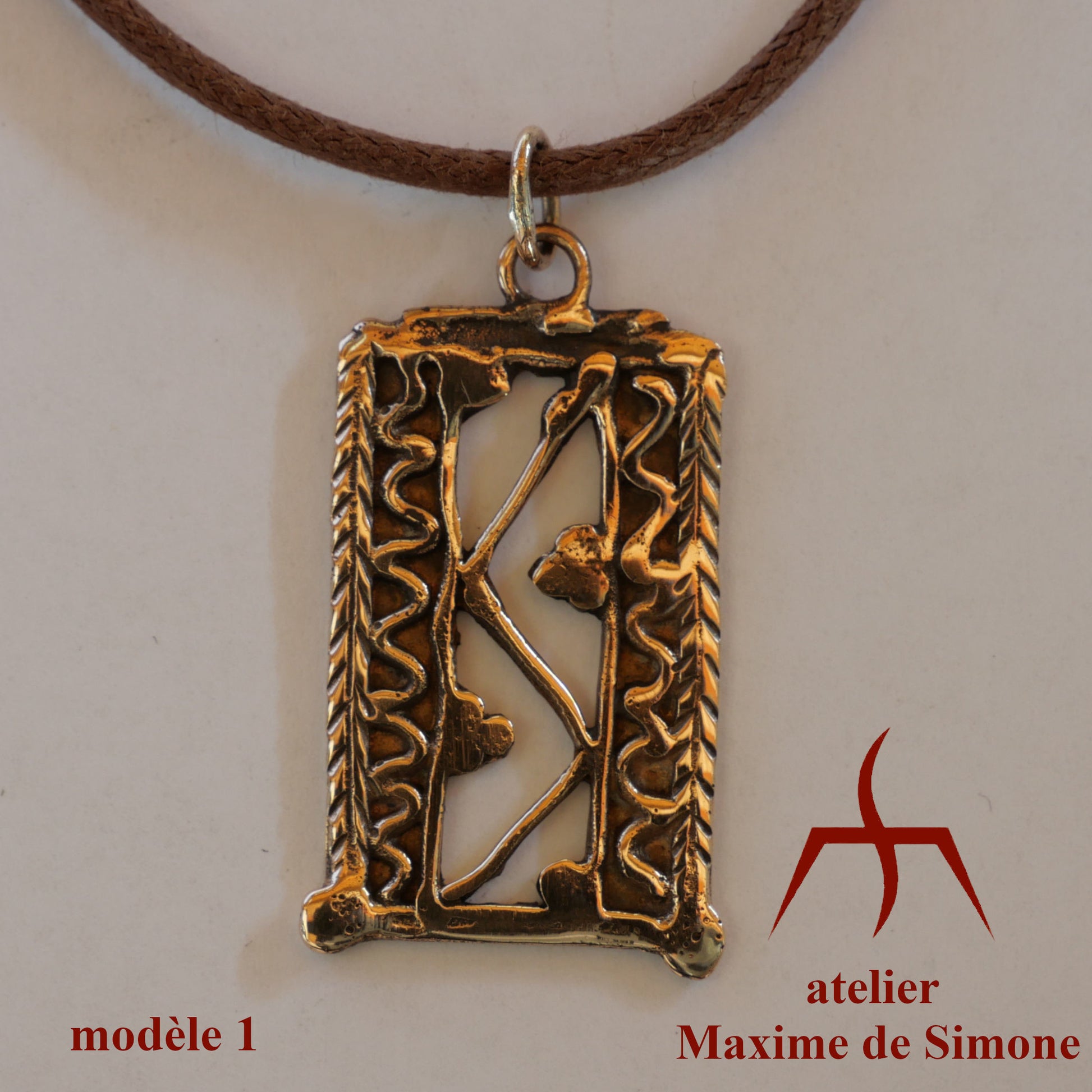 Pendentif en bronze découpé, décoré de motifs soudés