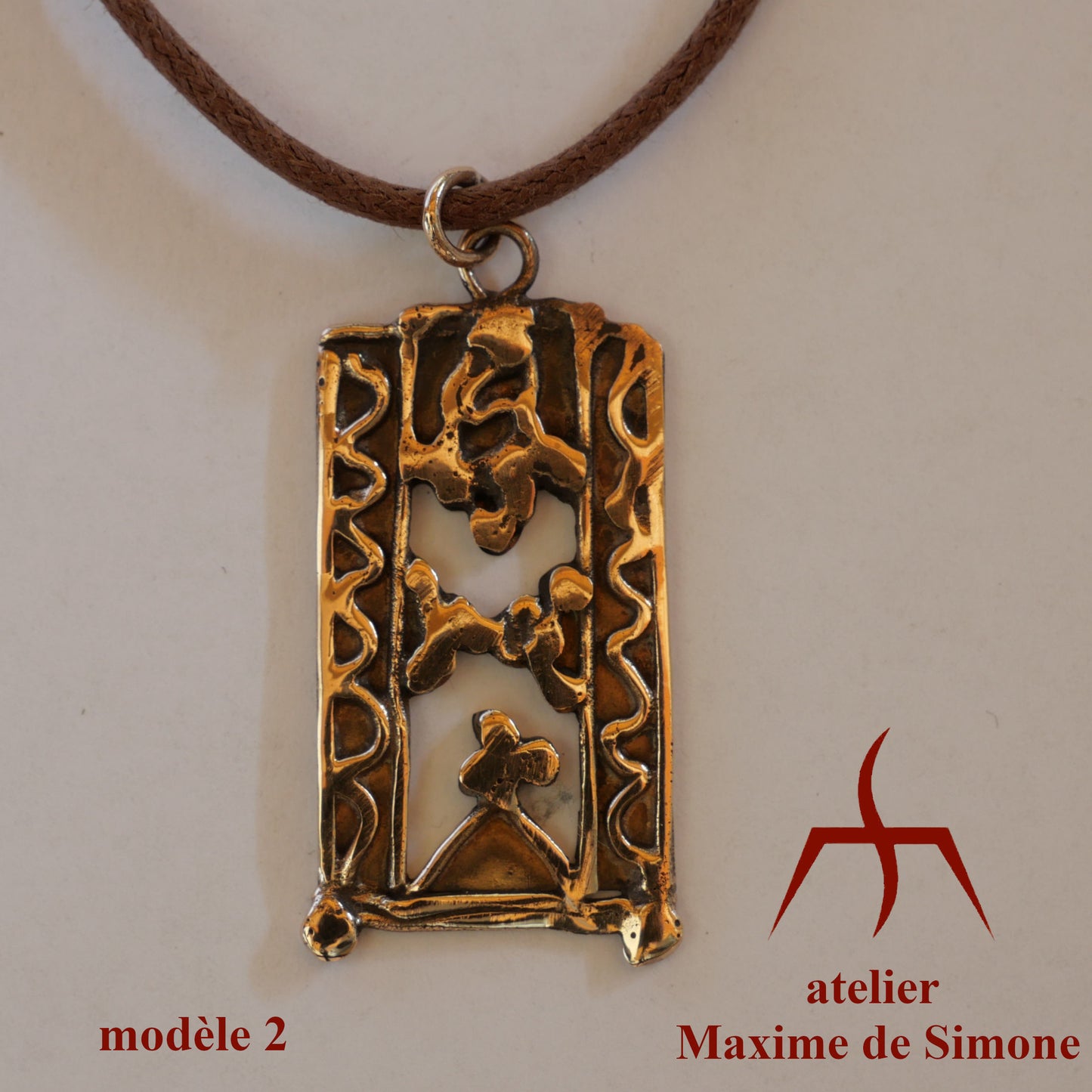 Pendentif en bronze découpé, décoré de motifs soudés