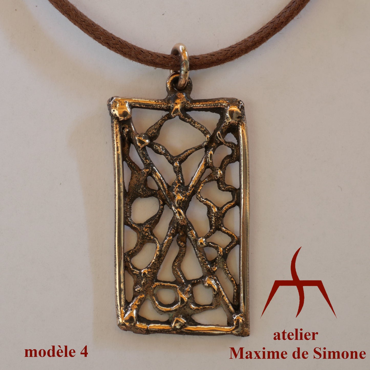 Pendentif en bronze découpé, décoré de motifs soudés