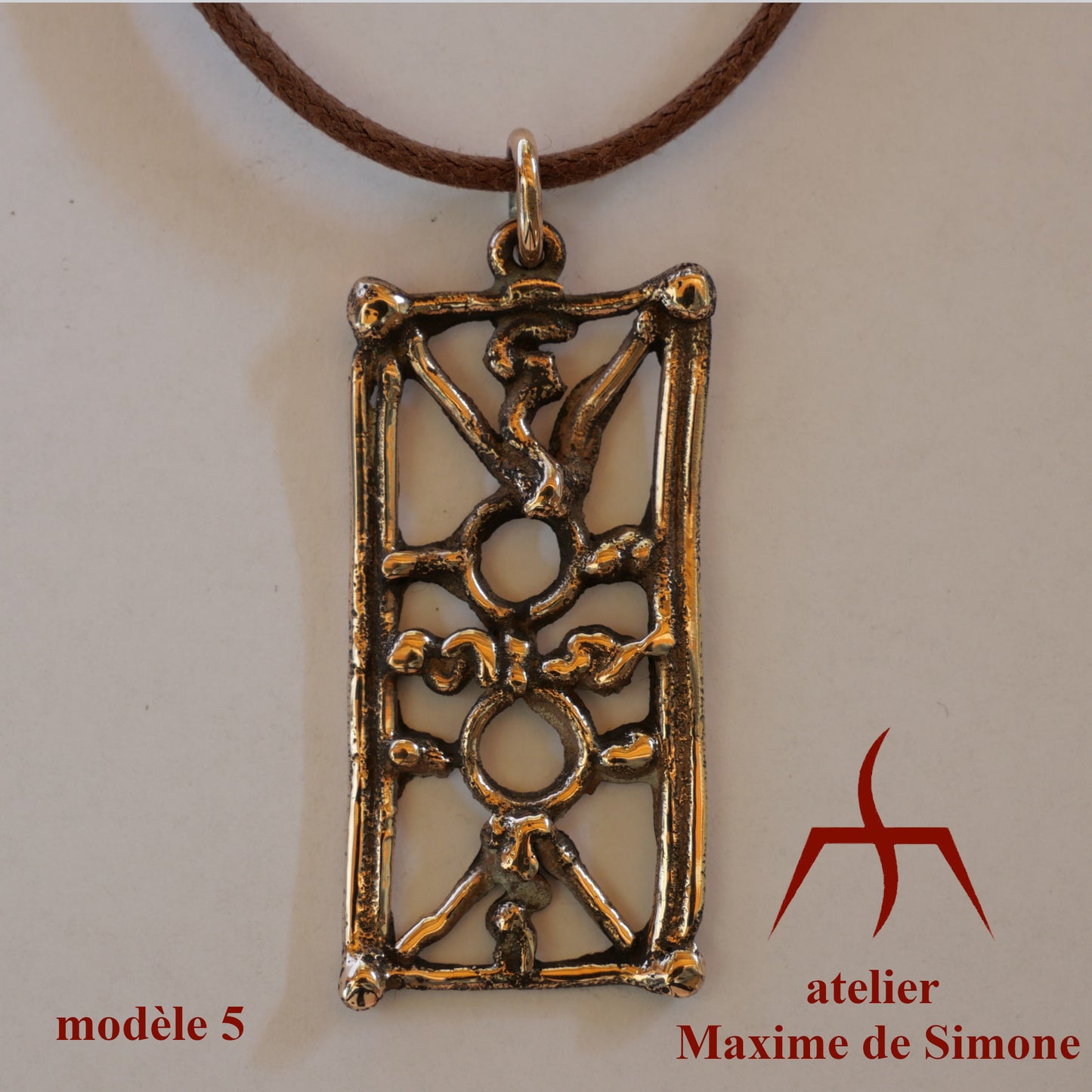 Pendentif en bronze découpé, décoré de motifs soudés