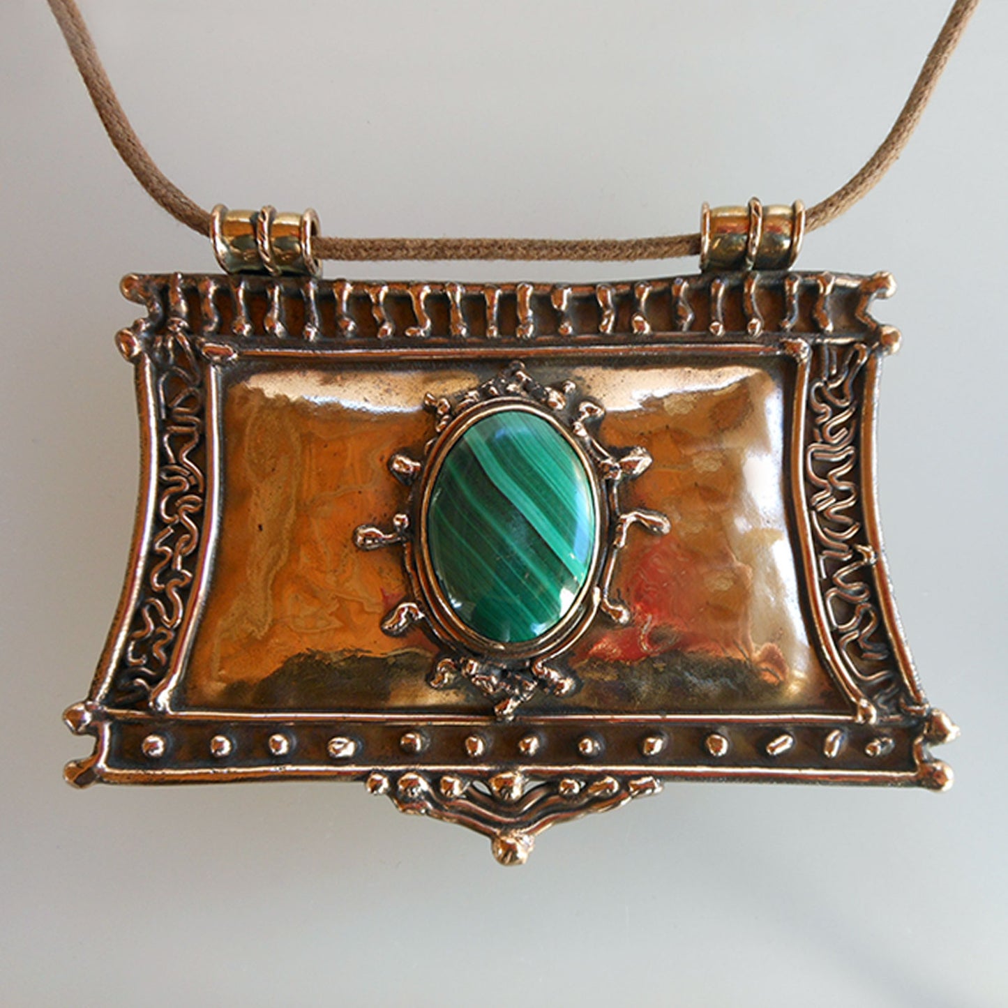 Pendentif en&nbsp; bronze décoré de motifs soudés orné d'un cabochon