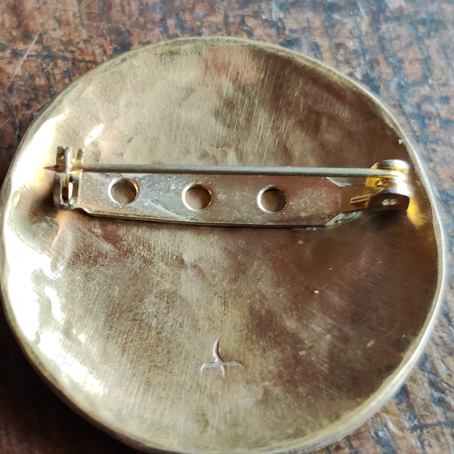 round bronze brooch decorated with welded patterns