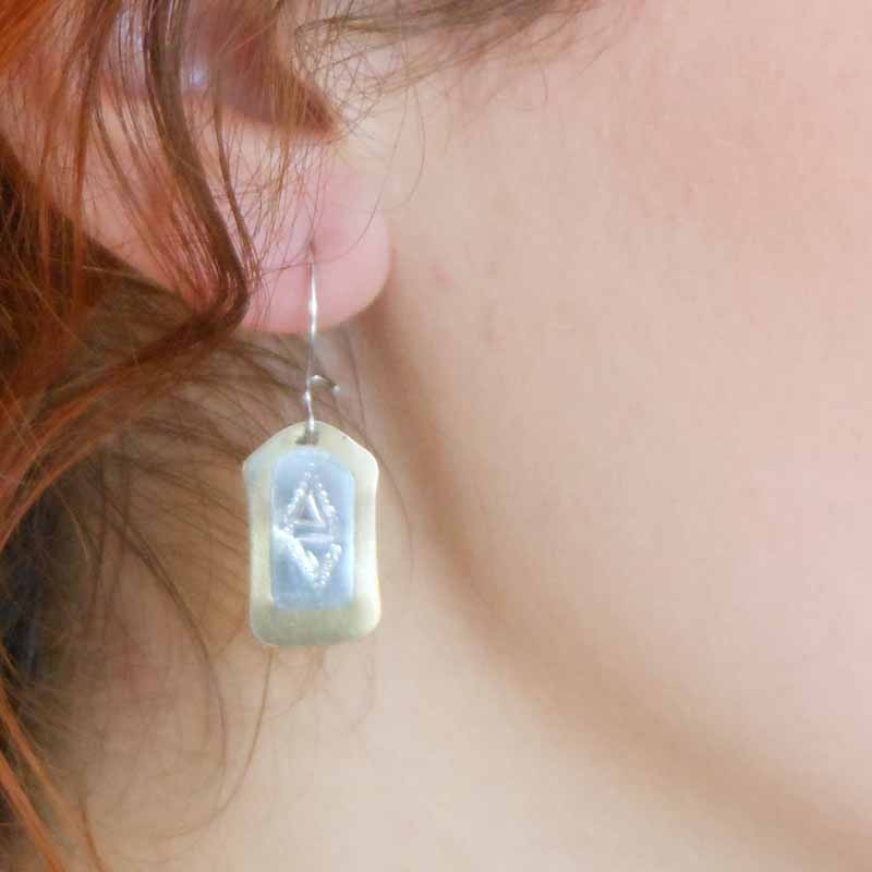 boucles d’oreilles en bronze avec une plaque d’argent décorée de motifs gravés