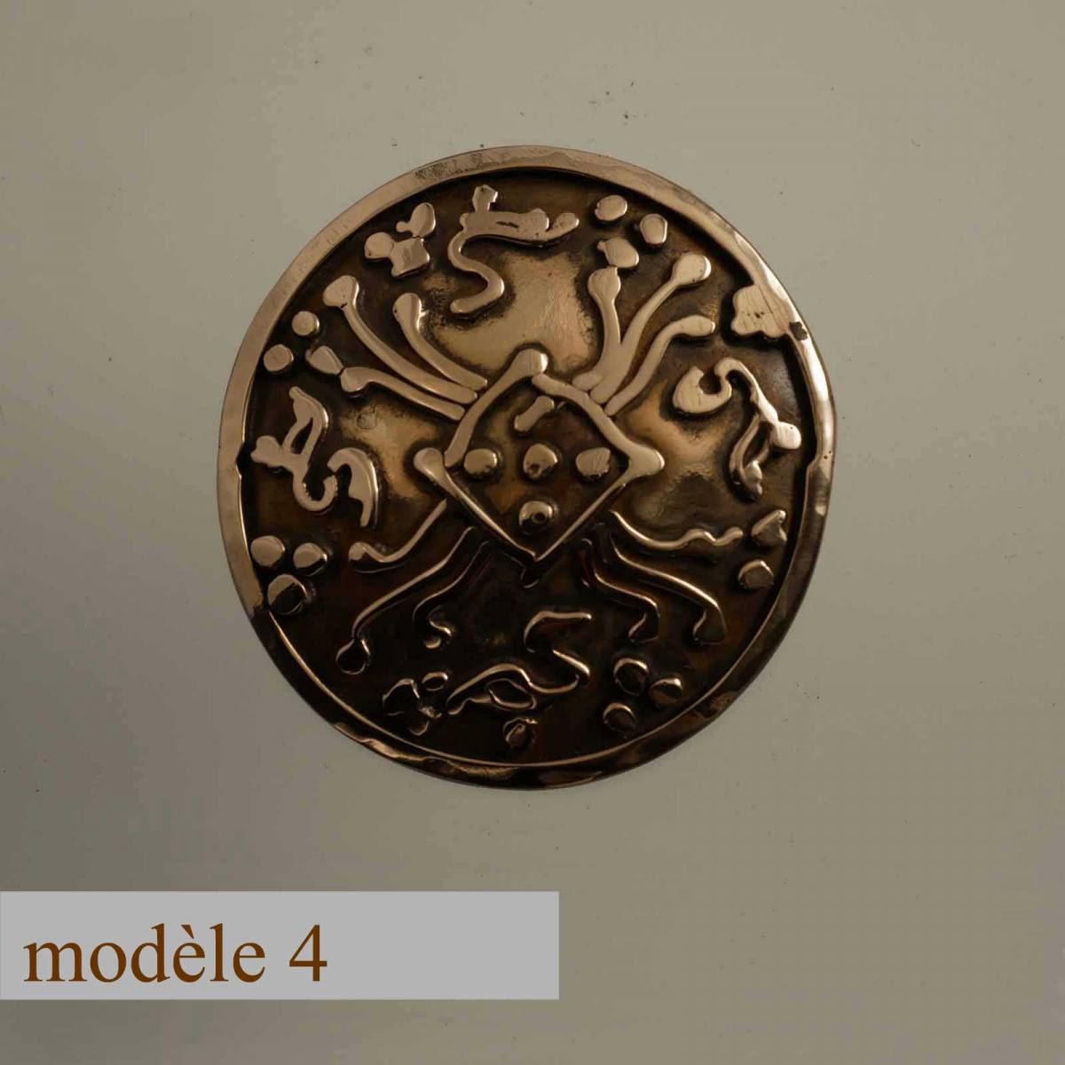 broche ronde en bronze décorée de motifs soudés