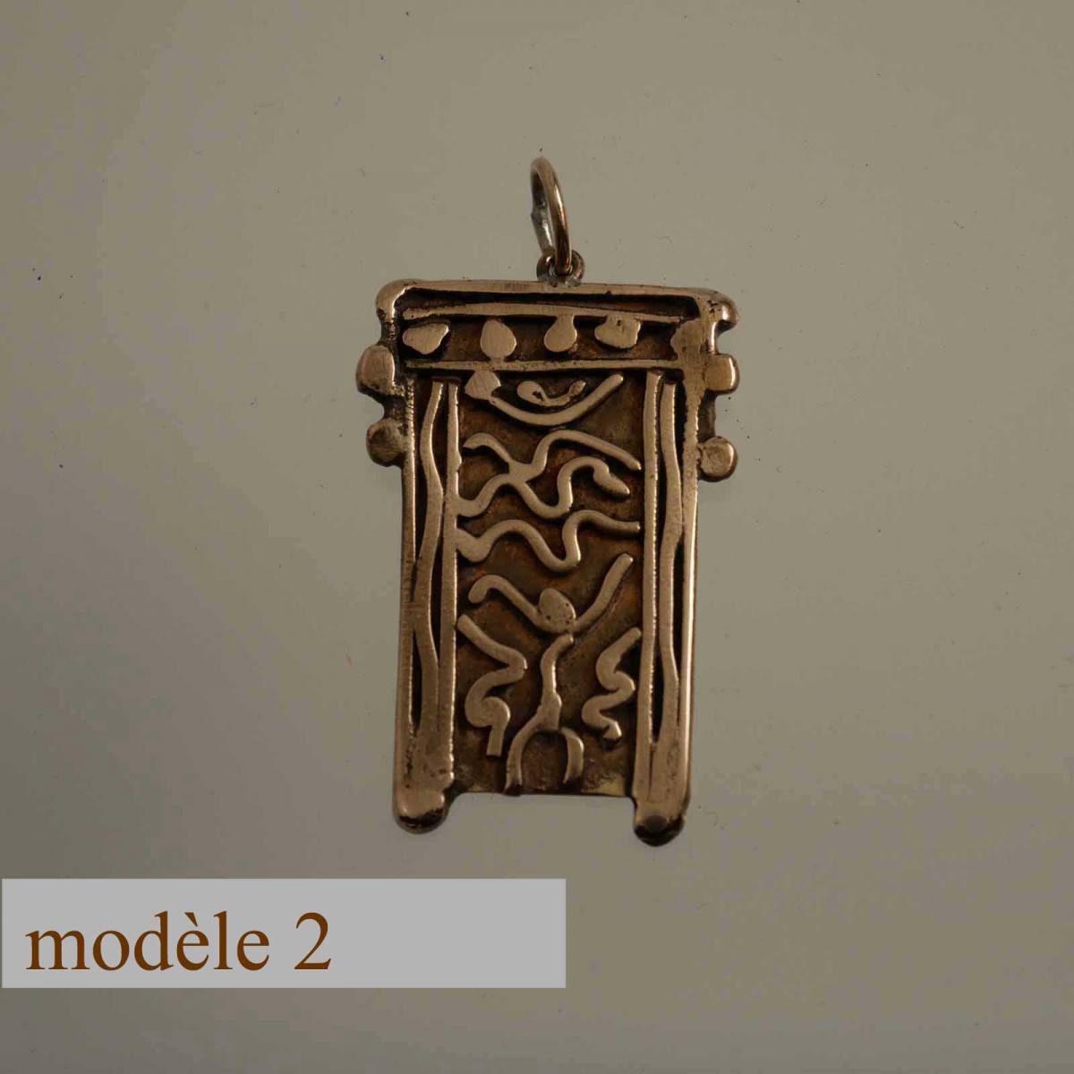 bronze pendant decorated with carved motifs