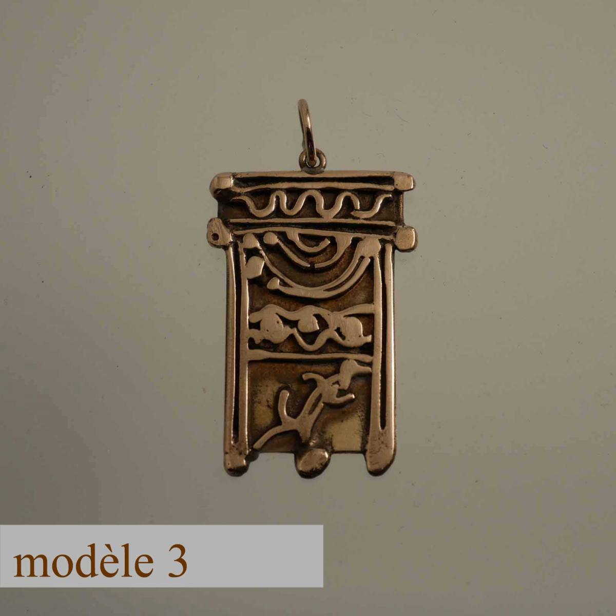 pendentif en bronze décoré de motifs sculptés